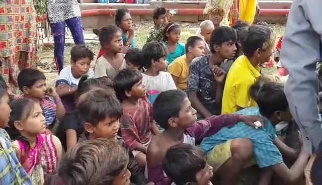Shubhkarman volunteers with children and families at a distribution drive