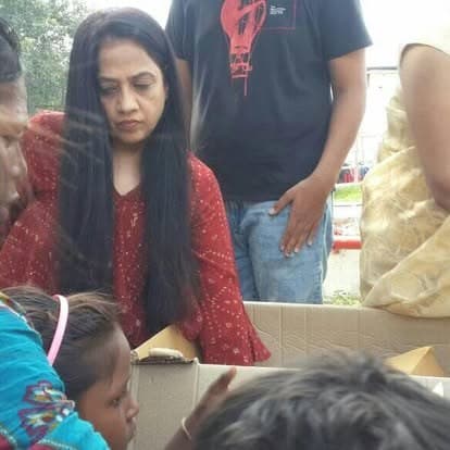Shubhkarman volunteers with children and families at a distribution drive